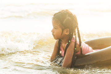  kid swim ring play on sea at sunset
