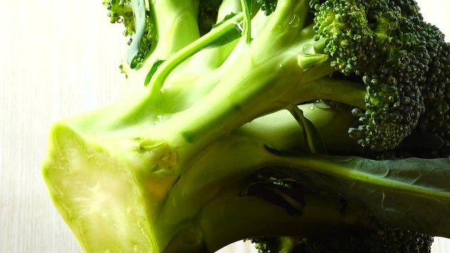 Shooting of broccoli in the movement. Cuttig board.