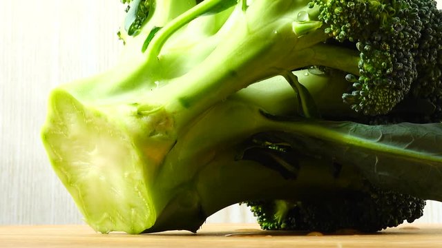 Shooting of broccoli in the movement. Cuttig board.