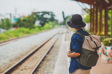 man with backpack walking away on railroad and emphasize to patience and survey trying step forward to goal. copy space