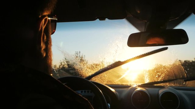 Wipers cleaning a dirty car wind shield with cleaner