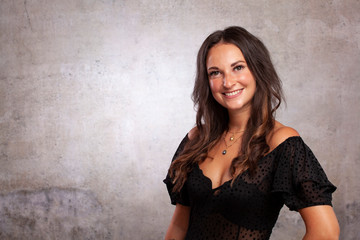Fototapeta premium Junge Frau Braune Haare Business mit Whitespace Betonwand