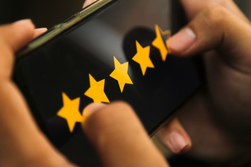 attractive hands giving four point five star rating on a smart phone
