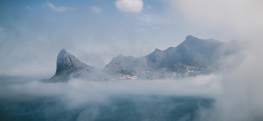 Fototapeta na wymiar Misty mountains around ocean bay