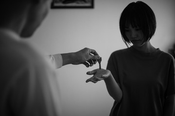 悲しそうに鍵を受け取る女性