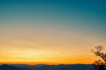 silhouette shot image of mountain and sunset sky in background.
