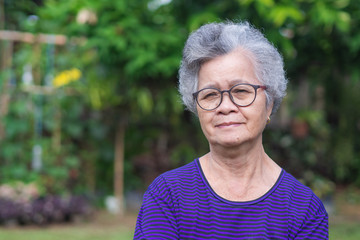 Senior woman short white hair stands in the garden