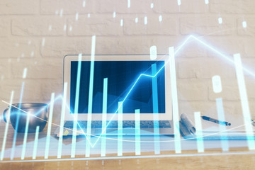 Stock market graph on background with desk and personal computer. Multi exposure. Concept of financial analysis.