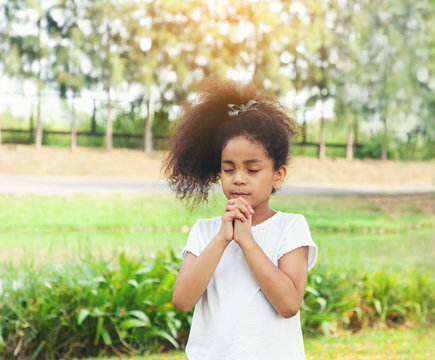 Little cute girl praying, spirituality, religion and believe concept.