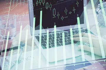 Multi exposure of market chart with man working on computer on background. Concept of financial analysis.