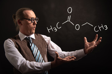 Professor presenting handdrawn chemical formula of ethyl acetate