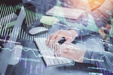 Stock graph with businessman typing on computer in office on background. Concept of analysis. Double exposure.
