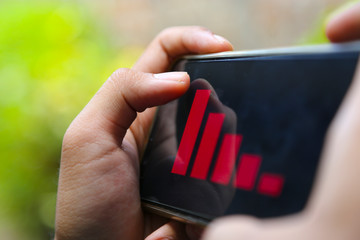 attractive hands showing decrease graph on a smart phone