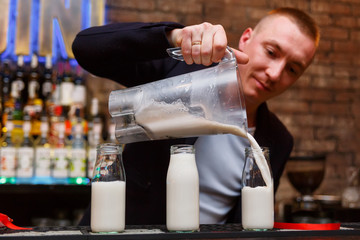 Fototapeta na wymiar The bartender making milk cocktail