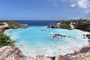 Fototapeta na wymiar Blue Lagoon Nusa Ceningan is a cove filled with bright turquoise water and popular spot among thrill seekers looking for cliff jumping
