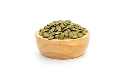 Green pumpkin seeds in a bowl on a white background.