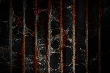 Old prison rusted metal bars cell lock and cobweb or spider web with blood stain on black...