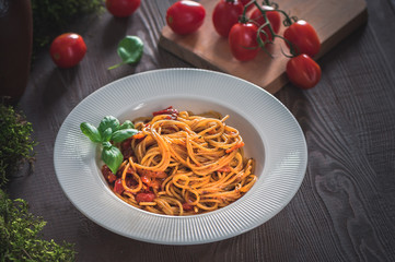 Spaghetti with tomato sauce on rustic background