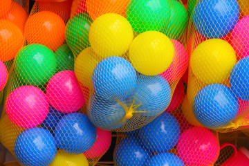 Colorful balls in gold or yellow net bag , toy multicolored  background