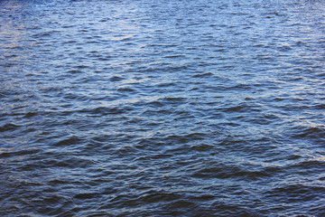 Water surface abstract background of river or sea water pattern with small waves. Natural calm water texture of blue seaside coastline waters