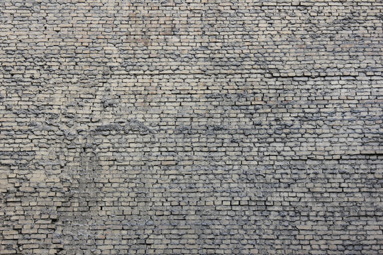 Fototapeta Grey brick wall vintage background with abstract grunge stone pattern. Textured  brickwork surface with cracks and blank copy space 