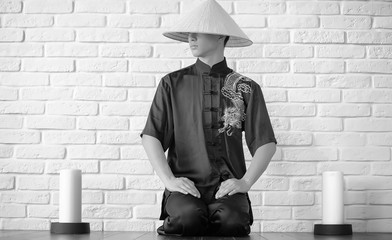 Asian novice on a white brick wall