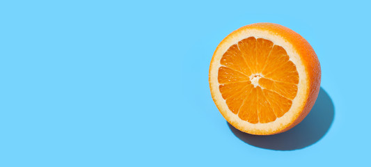 Ripe juicy delicious orange on blue background. Healthy eating and dieting concept