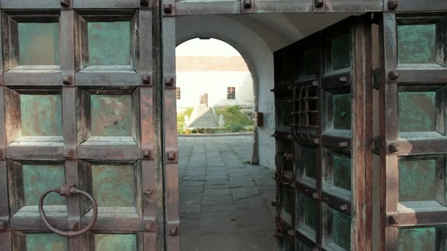 big wooden gates of the ancient castle, with green color shabby walls