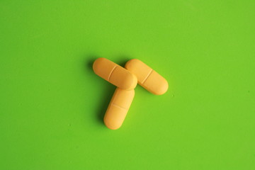 orange elongated pharmacy pills on colored background