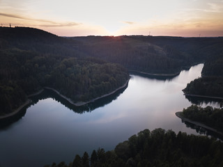 Blue lake and green forest during sunset