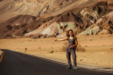 Fototapeta premium hitchhiker woman walking on a road in USA
