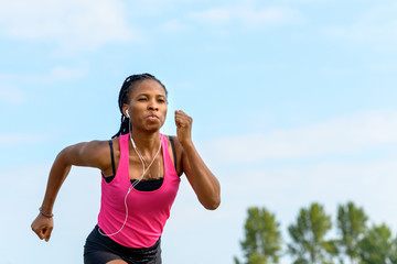Fit determined young African woman jogging