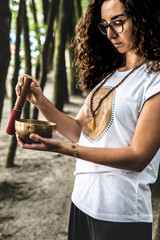 Kobieta, szamanka gra na misie dźwiękowej. Medytacja w lesie. Masaż dźwiękiem. 