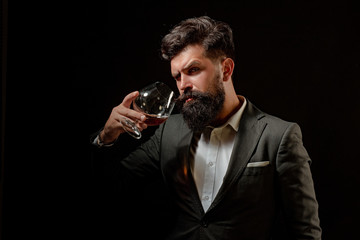 Alcohol concept. Stylish elegant bearded man Bartender holds cognac glass. Man or businessman...