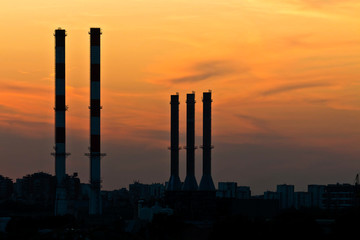 Fototapeta na wymiar Silhouettes of the industrial chimneys