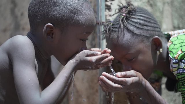 Couple of Black African Children Drinking Water from tap, Human Rights, Poverty, Climate Change