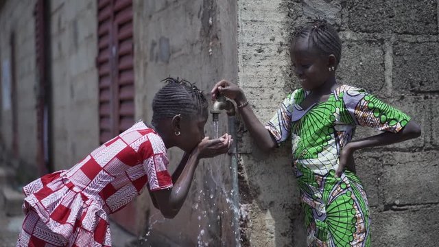 Two Gorgeous African Children Girls Drinking Freshwater in Bamako, Mali