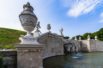 Fototapeta premium White stone Fountain with sculptures in the garden. baroque white fountain with water splashes