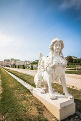 Obraz premium Beautiful white statue with a lion body and a female head. Ancient sculpture in the park