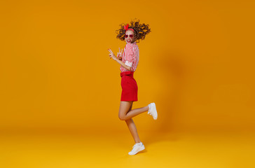 concept happy emotional young woman in red  jumping   on yellow background