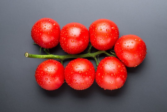 Beautiful red tomatoes with drops on a black background.