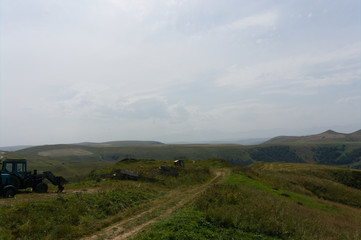 farm tractor on lawn meadows in the caucasus landscape near mount elbrus at the gumbashi pass