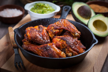 Grilled hot and spicy chicken wings with guacamole