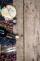 Top view Wine Background Wine Bottles Black and Pink Ripe Grapes on Wooden Background Vertical Copy Space
