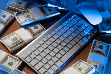 Money is near the keyboard. Concept - work at the computer. Freelance Investment in digital technology.Remote work on the Internet. Keyboard and dollars as a metaphor - freelancer.Work on the Internet