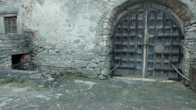 large wooden gates of the ancient castle, with shabby walls
