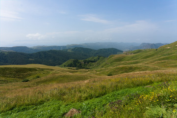 Fototapeta na wymiar Gumbashi pass view in the russian caucasus, green meadow landscape at an altitude of above 2000 m