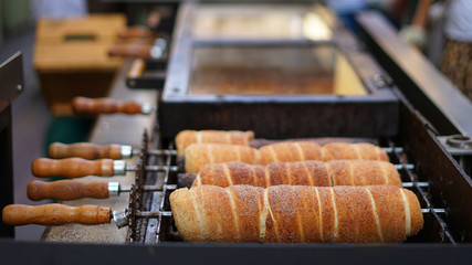 Making Trdelnik with sugar and cinnamon, popular traditional Czech cake or sweet pastry