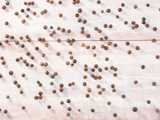 Allspice (Jamaica pepper) on a brown wooden background