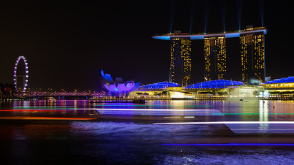 Singapore skyline panorama background with light tracks of tourist boats at night in Singapore city